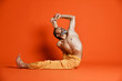 © FAB.1 - Old man practicing yoga doing stretching exercises against orange background