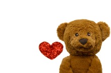 The Smiling Teddy Bear With Blurred Photo Of Love Shape Bokeh That Taken From Red Glitter Paper Isolated On White Background For Valentine's Day That Celebrate In 14 February Of Every Year.