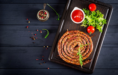 Wall Mural - Baked homemade sausage on a wooden board. Thanksgiving Day. Top view.