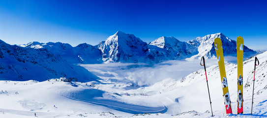 Ski in winter season, mountains and ski touring backcountry equipments on the top of snowy mountains in sunny day. South Tirol, Solda in Italy.