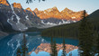 a mirror smooth moraine lake at sunrise in canada's banff national park