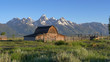 a sunrise wide shot of a mormon row barn and grand teton mountain in grand teton national park in the united states of america