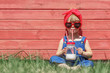 Little girl in dungarees and sun glasses is drinking milk. Colorful summer concept.