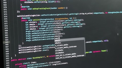 Programmer developer writing and editing code on computer screen