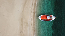 Aerial Drone Top View Photo Of Iconic Beach Of Psarou With Emerald Clear Sandy Organised Beach With Sunbeds And Umbrellas And Traditional Fishing Boat, Mykonos Island, Cyclades, Greece