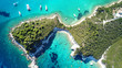 Aerial drone bird's eye view photo of sail boats docked in tropical caribbean paradise bay with white rock caves and turquoise clear sea