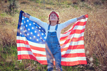 Boy In Nature Holding An American Flag