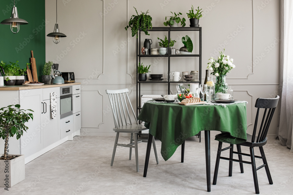 Elegant grey and green kitchen with breakfast on round dining room ...