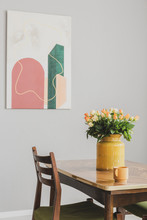Roses In Yellow Glass Vase On Elegant Wooden Table In Vintage Dining Room