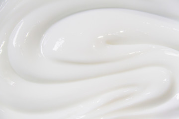 The white surface of the cream lotion softens the background.