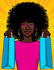 Wall Mural - Color vector  pop art style  illustration of a girl with packages.  Beautiful young African American girl holding shopping bags. Happy girl in pink glasses goes shopping. Stylish girl with curly hair