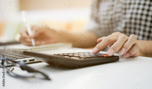 Fotografía close up grandmother hand press on calculator for counting about monthly expense