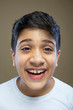 © IndiaPix - Close up portrait of cute little boy laughing against color background