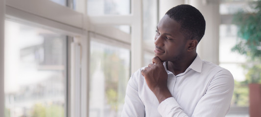 Thoughtful African man thinking; portrait of pensive young adult african man thinking or planning; good idea, future, brain storming concept; African young adult black man model