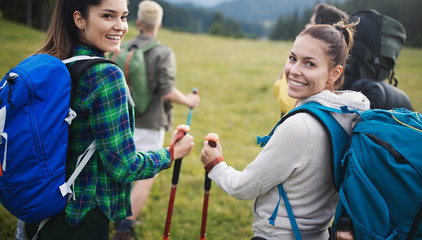 Group of young friends hiking in countryside. Multiracial young people on country walk.