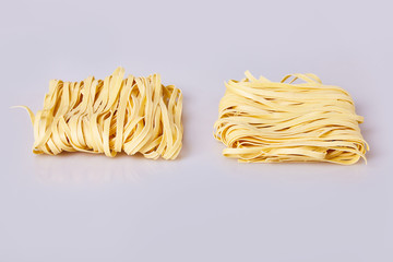 Dry thick rolled noodles square shape. Capelli d'angelo, Angel's hair - pasta.  Homemade italian pasta tagliatelle. Italian Cuisine. Egg noodles. Isolated on white background