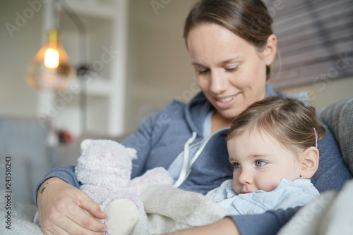 Mother Comforting Her Young Daughter On Sofa At Home Buy This