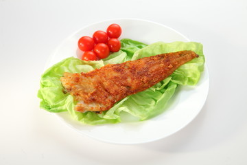 Fried sea fish with salad and six tomatoes