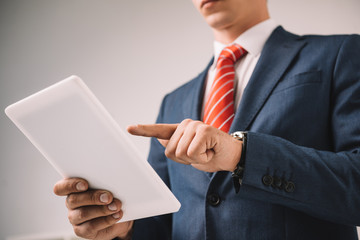 cropped view of businessman using digital tablet isolated on grey