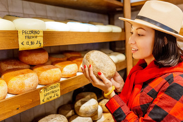 Woman choosing traditional italian pecorino cheese in local store