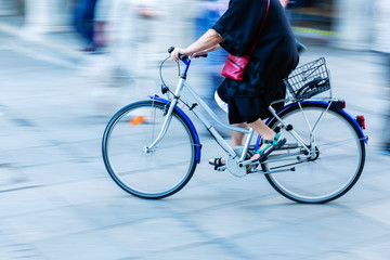 Wall Mural - older woman rides a bicycle in the city