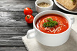 Dish with fresh homemade tomato soup and space for text on wooden table