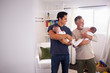 © Monkey Business - Young Hispanic man and his senior father holding his two baby boys at home