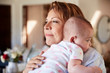 © Monkey Business - Middle aged Hispanic grandmother holding her newborn grandson, head and shoulders, close up