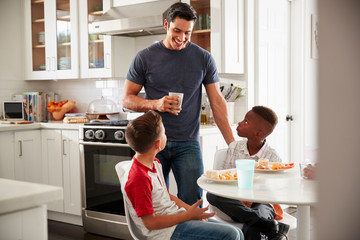 Wall Mural - Dad standing in the kitchen talking with his son and a friend, who is over for a playdate