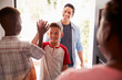 © Monkey Business - The two pre-teen boys high five in the open doorway, as dad drops his son off at his friendsÕ house