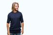 © Krakenimages.com - Young handsome man with long hair wearing winter sweater over isolated background looking away to side with smile on face, natural expression. Laughing confident.