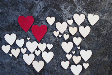 A lot of wooden and two red decorative hearts on black background. Valentine's Day Concept.