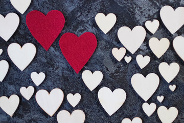 A lot of wooden and two red decorative hearts on black background. Valentine's Day Concept.