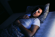 Young Man Using Smartphone In Bed At Night