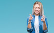 © Krakenimages.com - Young blonde woman over isolated background pointing fingers to camera with happy and funny face. Good energy and vibes.