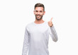 © Krakenimages.com - Young handsome man over isolated background doing happy thumbs up gesture with hand. Approving expression looking at the camera with showing success.