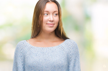 Young beautiful caucasian woman wearing winter sweater over isolated background smiling looking side and staring away thinking.