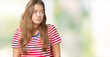 © Krakenimages.com - Young beautiful brunette woman wearing stripes t-shirt over isolated background making fish face with lips, crazy and comical gesture. Funny expression.