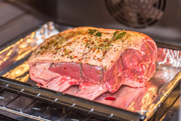 closeup view raw beef cross rib chunk on oven tray with foil inside oven