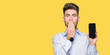 © Krakenimages.com - Young handsome man business showing smartphone screen cover mouth with hand shocked with shame for mistake, expression of fear, scared in silence, secret concept