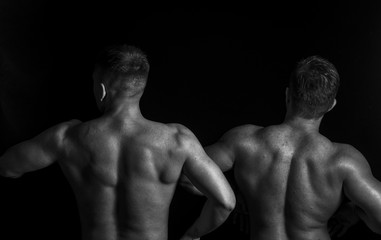 Two bodybuilders isolated on balck background