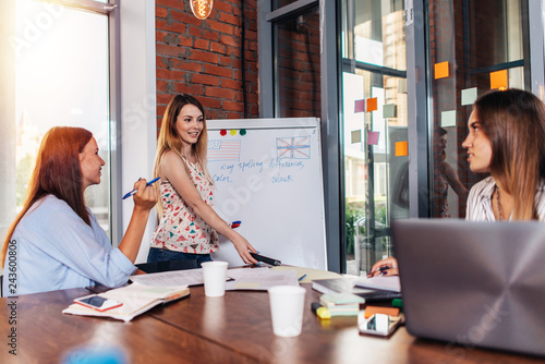 Foto Young woman teaching English to adult students at language school