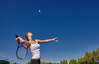 a Girl playing tennis on the court on a beautiful sunny day
