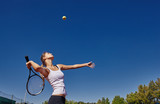 Fototapeta Desenie - a Girl playing tennis on the court on a beautiful sunny day