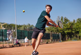 Fototapeta Desenie - a Man playing tennis on the court on a beautiful sunny day