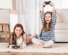 Excited Sisters Playing Games