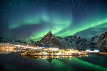 Wall Mural - aurora borealis over mountains in scandinavian village glowing