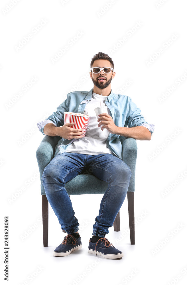 Young man with popcorn watching movie on white background