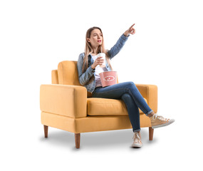 Young woman with popcorn watching movie on white background