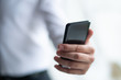 © Mangostar - Closeup of business man holding smartphone. Person using holding smartphone. Communication concept. Cropped view.